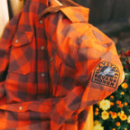 Levitate x Evan Honer Original Flannel, sleeve: close-up of the black Evan Honer owl patch on the left sleeve, with Fall mums behind