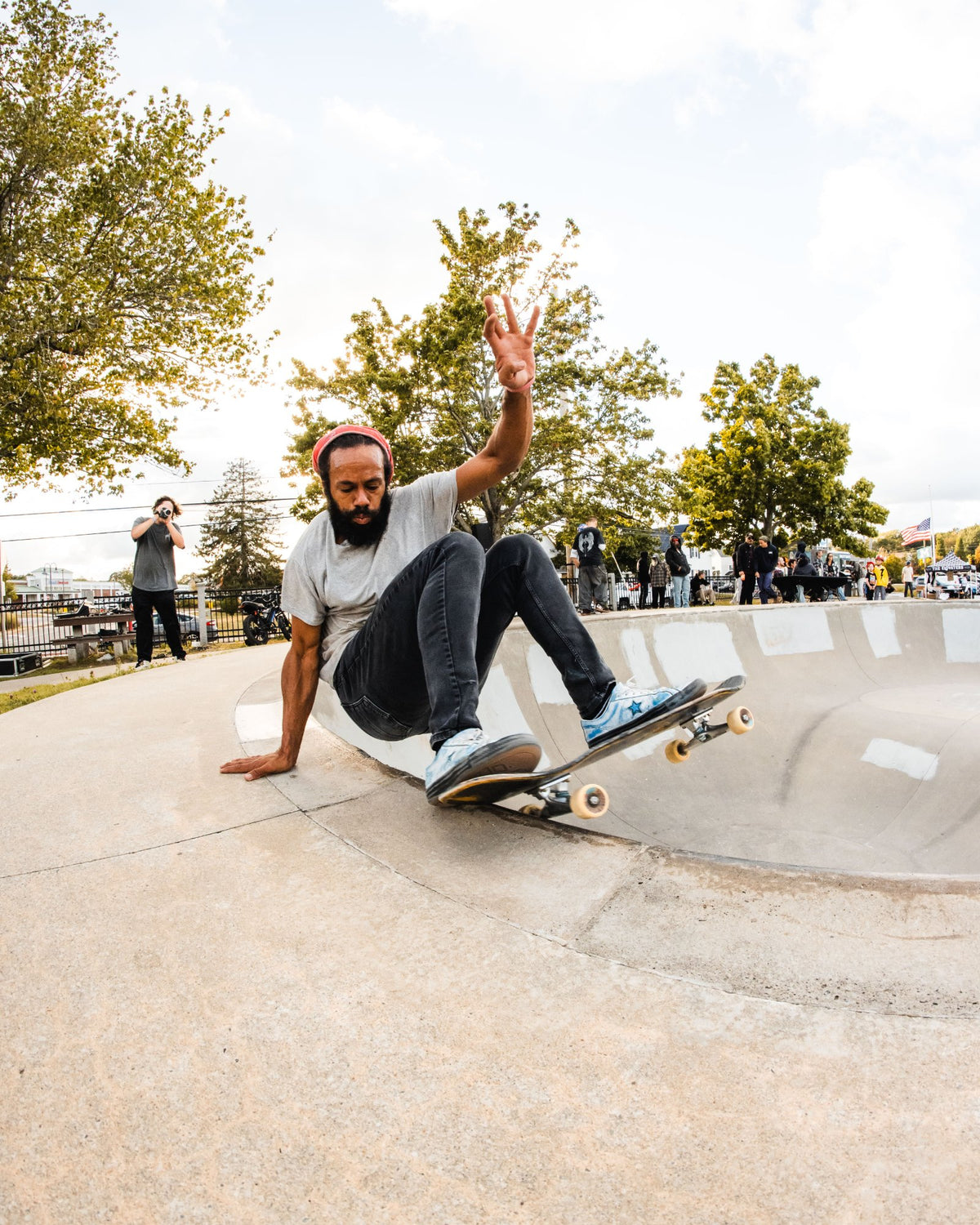 Skater carving the bowl wall with one hand up at the Shark Belly Classic