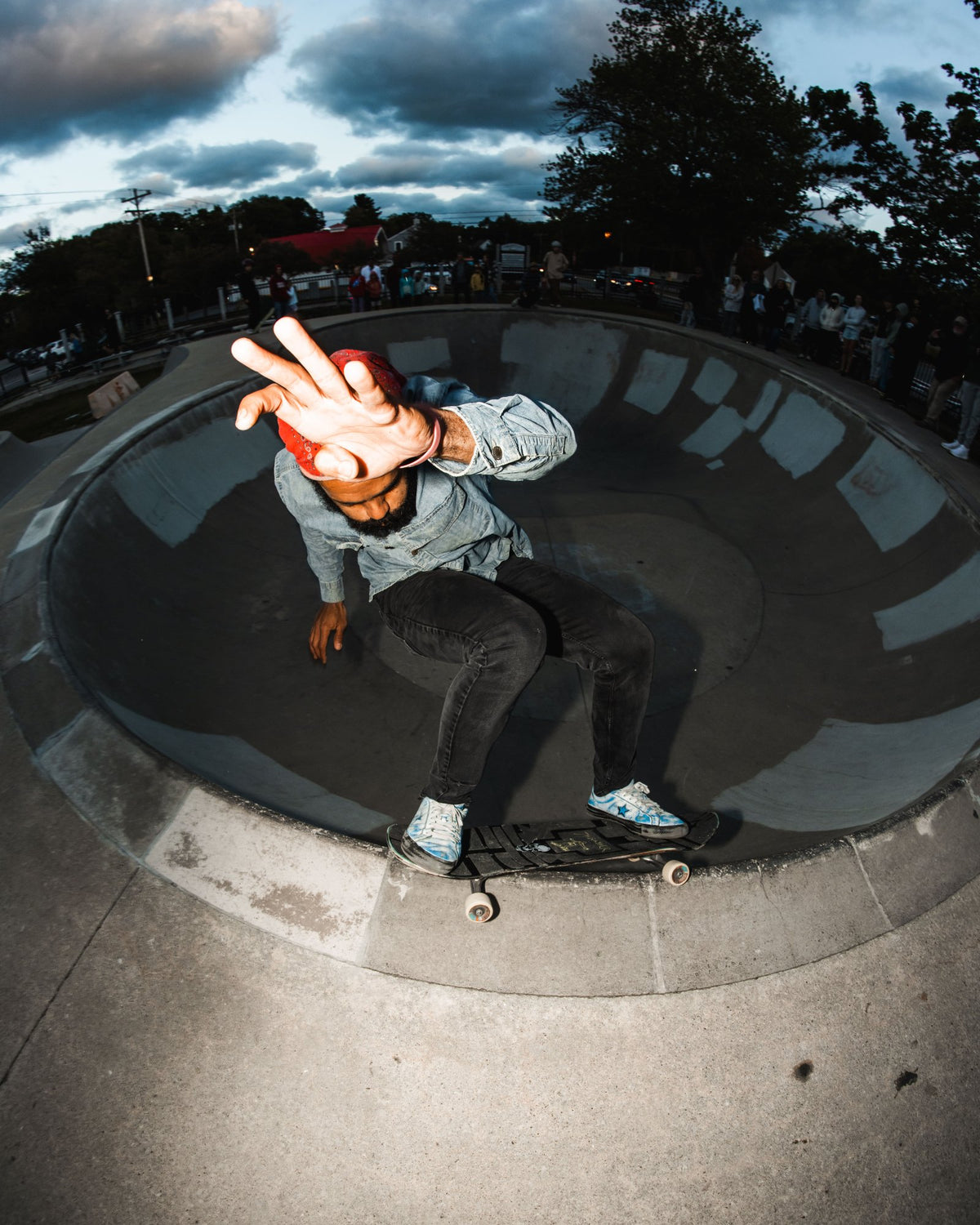 Skater grabbing his board in the bowl at the Marshfield skatepark at dusk