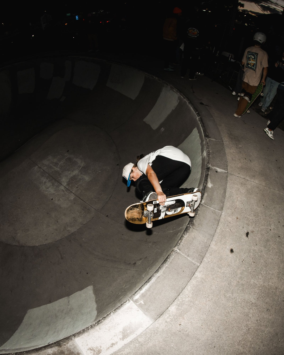 Skater dropping into the bowl under the lights at night during the Shark Belly Classic