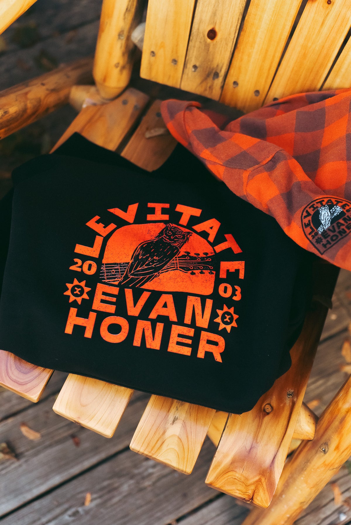 Levitate x Evan Honer black hoodie with orange collab graphic on a wooden chair
