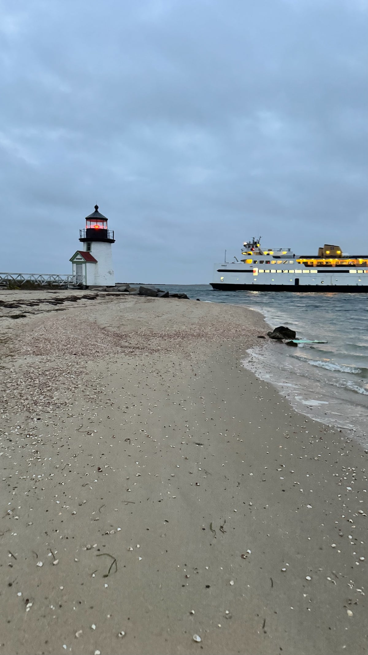 Brant Point Lighthouse on Nantucket with the ferry passing behind