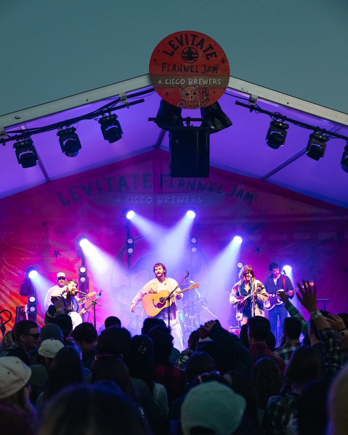 Crowd in front of the lit stage at Cisco Brewers as night falls during Flannel Jam Nantucket